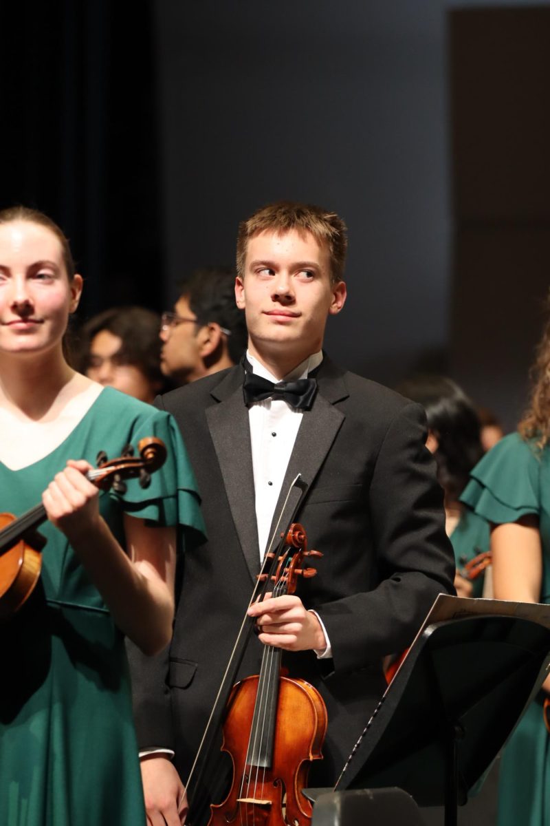 Luke Huber, sophomore, takes a bow during the winter orchestra concert.